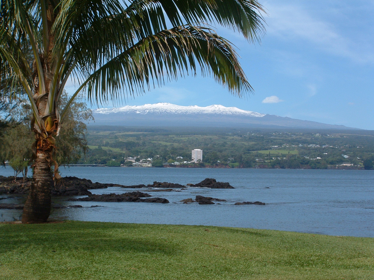 Snow covered Mauna Kea volcano above Hilo bay